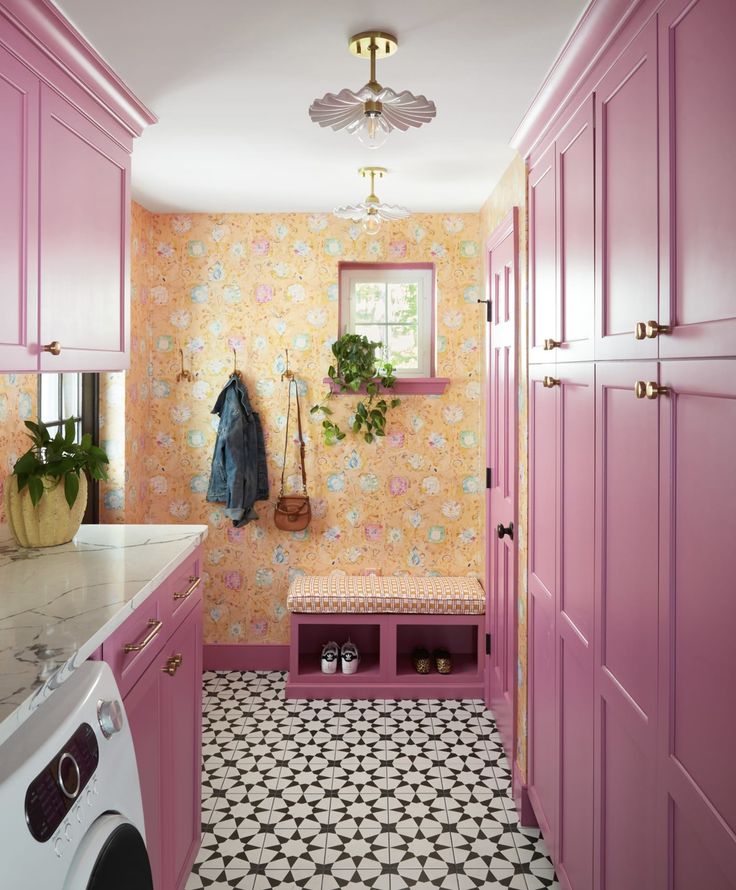 a laundry room with pink cabinets and tile flooring