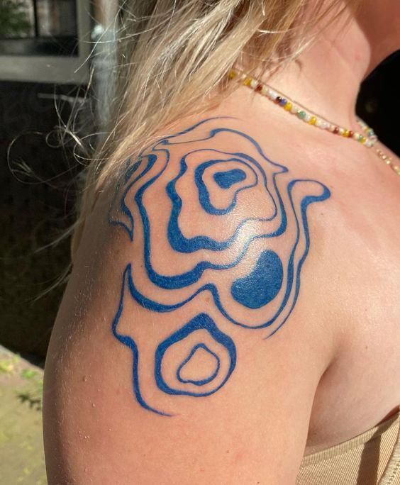 a woman with a blue tattoo on her shoulder