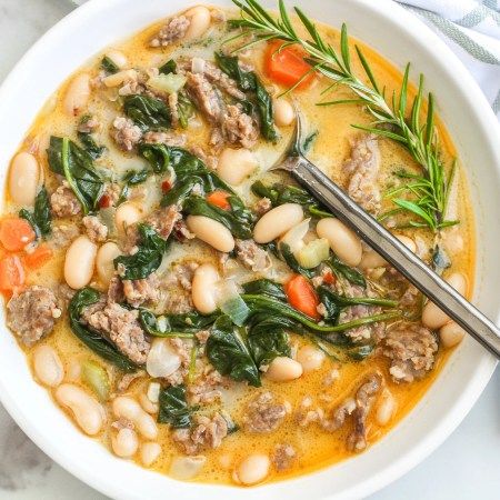 a white bowl filled with meat and bean soup