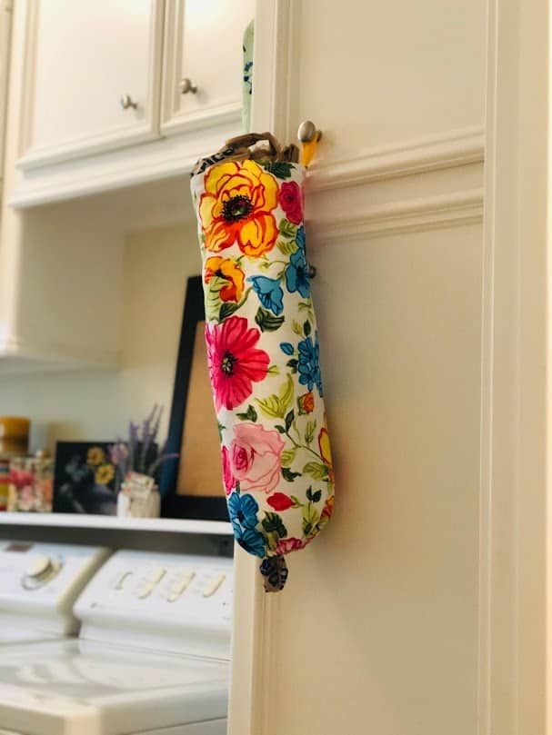 an umbrella hanging on the side of a kitchen door with a washer and dryer in the background