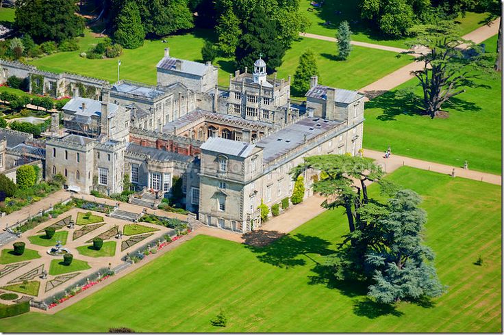 an aerial view of a large building in the middle of a green field with lots of trees