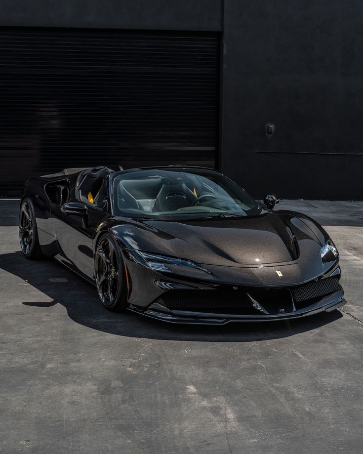 a black sports car parked in front of a garage