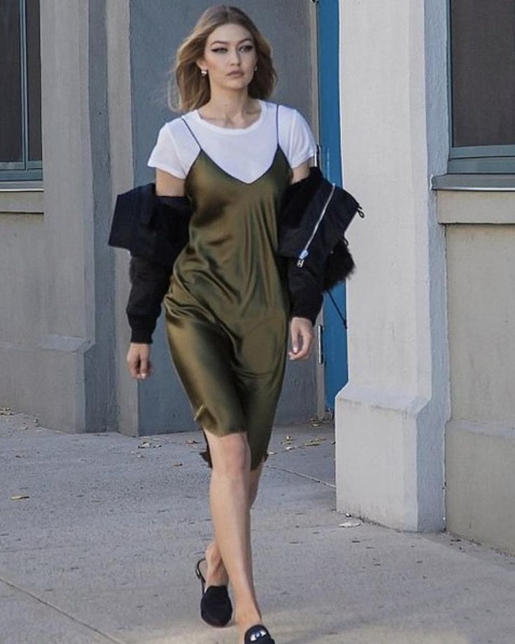 a woman is walking down the street in a green dress