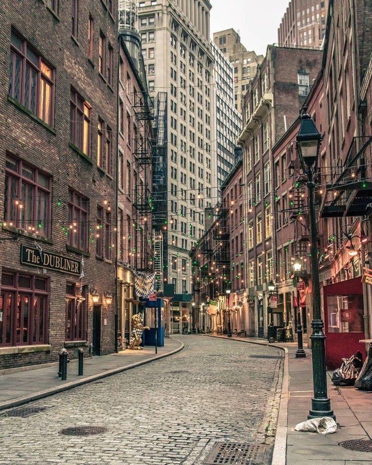 an empty city street with tall buildings in the background