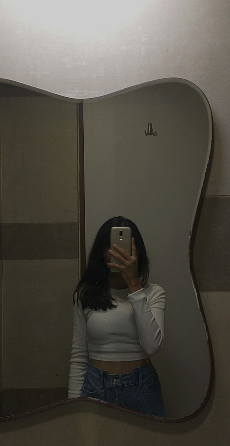 a woman taking a selfie in front of a mirror