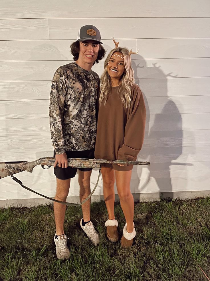 a man and woman are dressed up as deer hunters for the halloween costume contest in front of a house