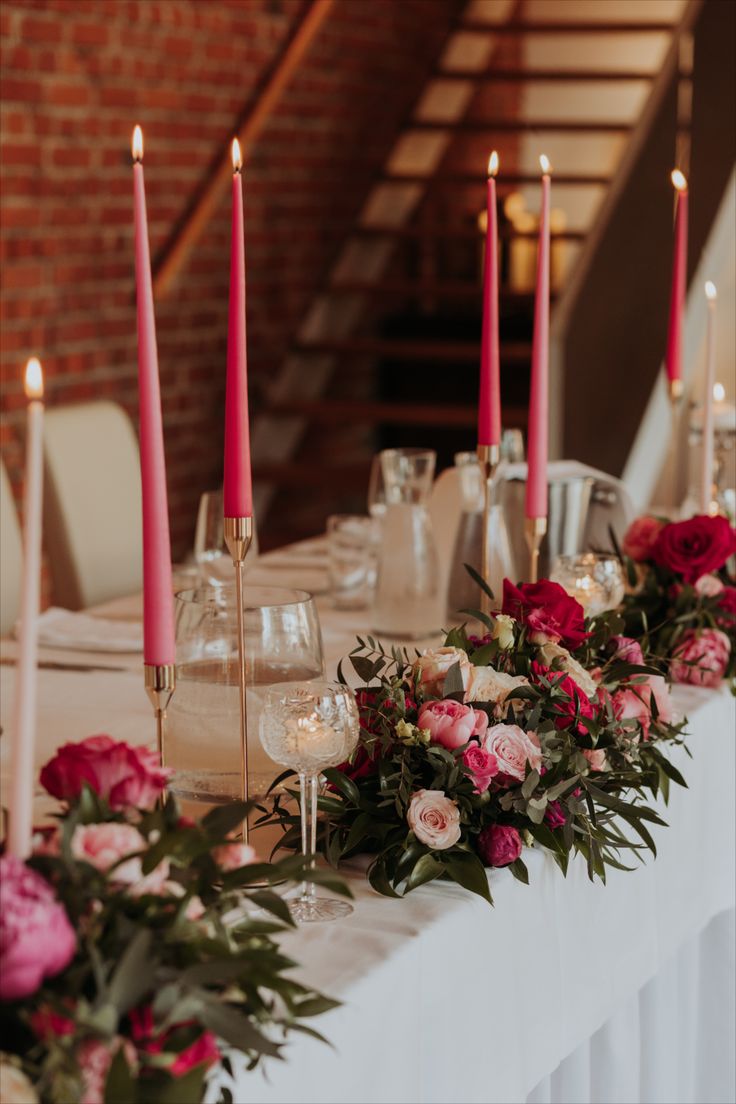 the table is set with candles, flowers and wine glasses for an elegant wedding reception