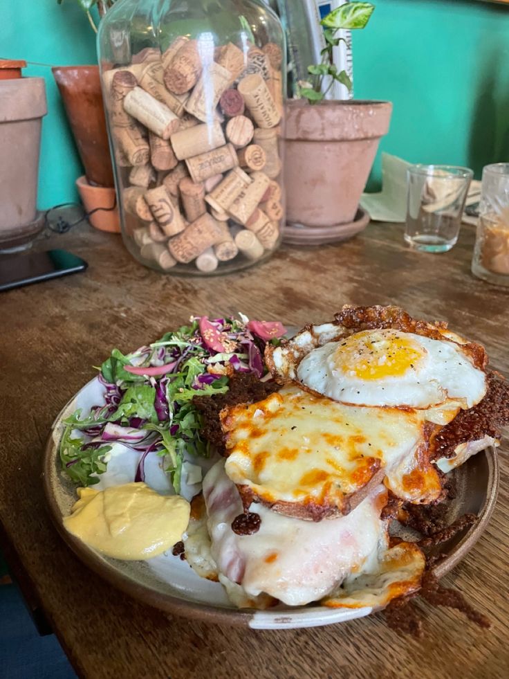 a plate full of food sitting on a table next to some wine bottles and glasses