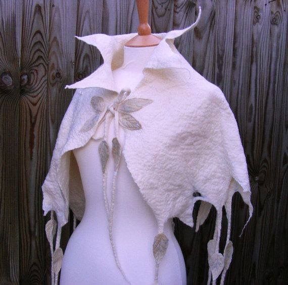 a mannequin wearing a white shawl with leaves on it's back