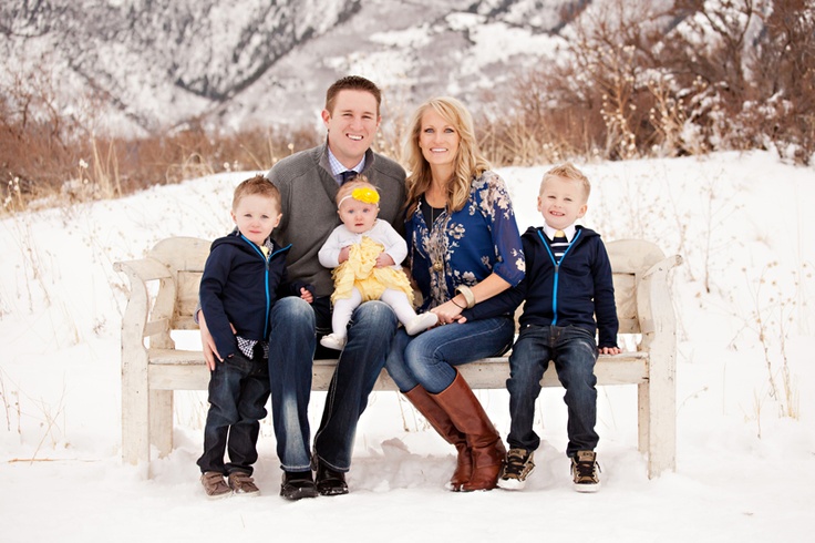 a family sitting on a bench in the snow