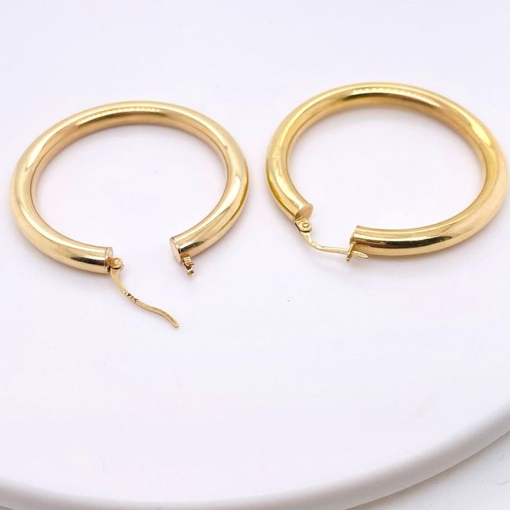 These stunning polished 14k yellow gold hoops provide a look that is both trendy and classic. While they were once worn by kings and queens to signify power and social status, hoop earrings are now considered a statement of unity and strength. Hoop earrings stand out, just like the strong people who sport them. These earrings are a great staple to add to your collection, and can be worn with both casual and formal wear. These hoop earrings would make the perfect gift for your loved one of yourse Classic Gold-tone Round Huggie Earrings, Gold Small Hoop Earrings For Everyday Luxury, Classic Gold Plated Pierced Hoop Earrings, Classic Gold-plated Hoop Earrings, Gold Small Hoop Classic Rings, Timeless Gold Plated Hoop Earrings For Anniversary, Small Hoop Gold Classic Rings, Classic Small Hoop Gold Rings, Classic Gold-tone Gold-plated Hoop Earrings