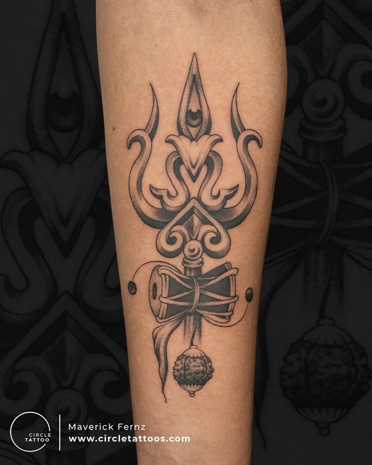 a black and white tattoo on the leg of a person with an ornate bow in it