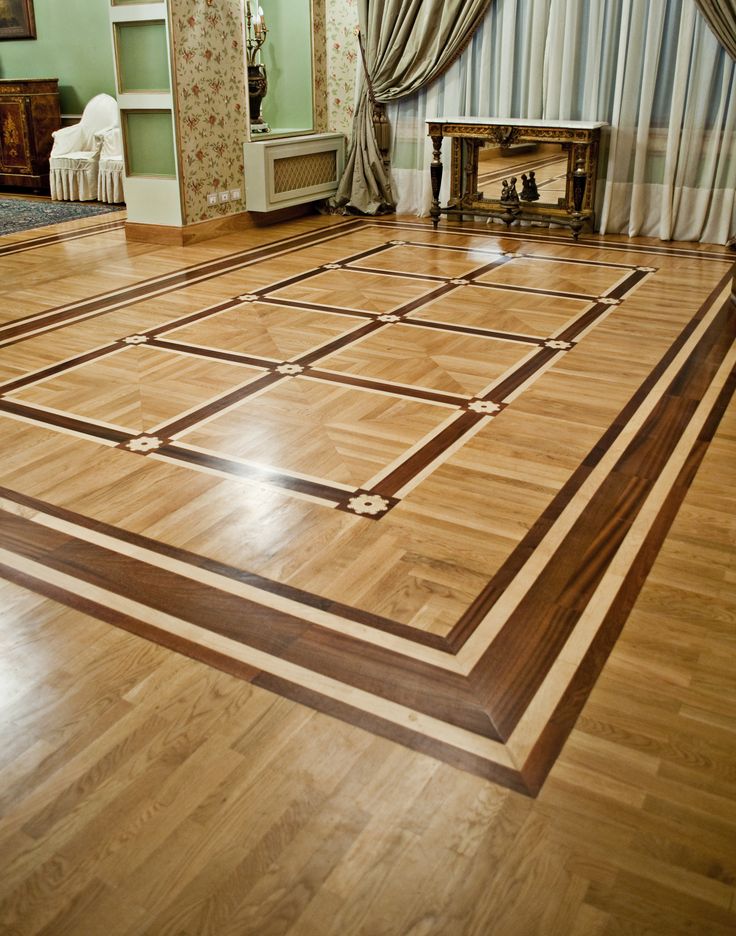 an empty room with wooden floors and curtains