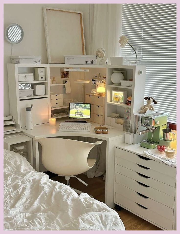 a desk with a computer on top of it in a room filled with white furniture