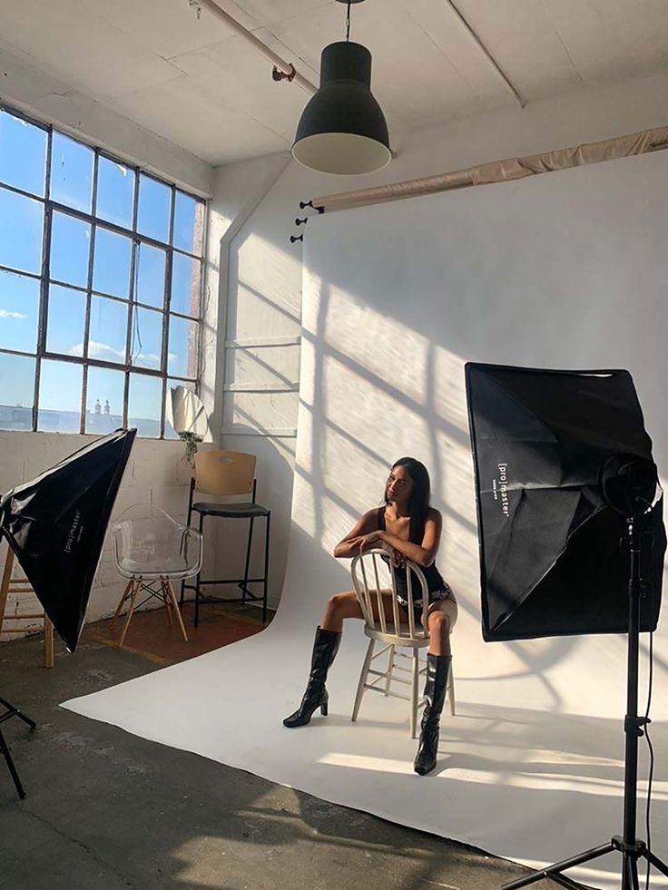 a woman sitting on a chair in front of a camera set up for a photo shoot