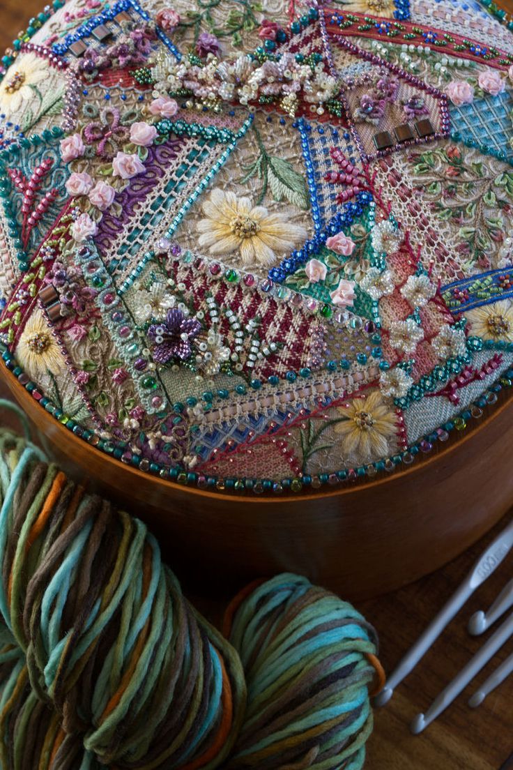 a close up of a wooden bowl with yarn on it