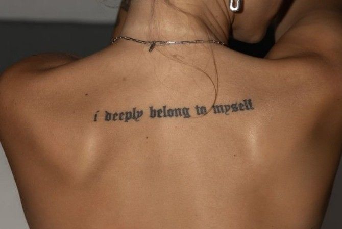 a woman with a tattoo on her back saying i deeply belong to himself