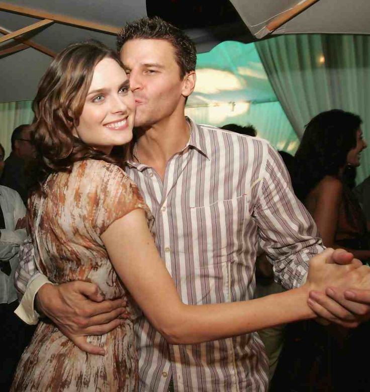 a man and woman hugging each other at a party