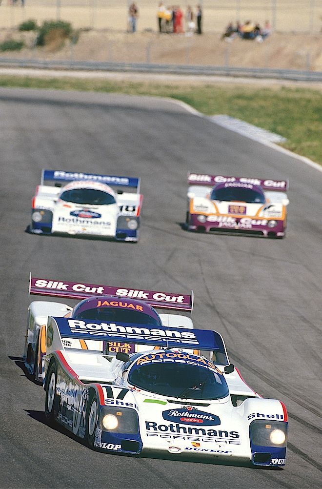 three cars racing on a race track during the day