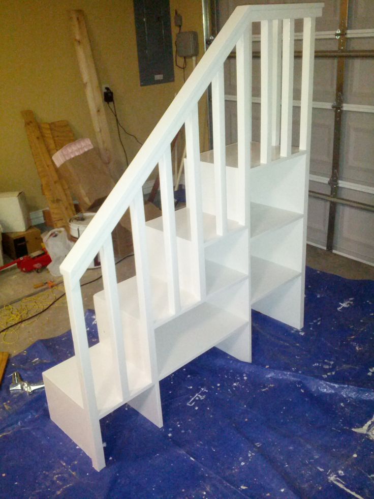 a white stair case sitting on top of a blue tarp next to a wall