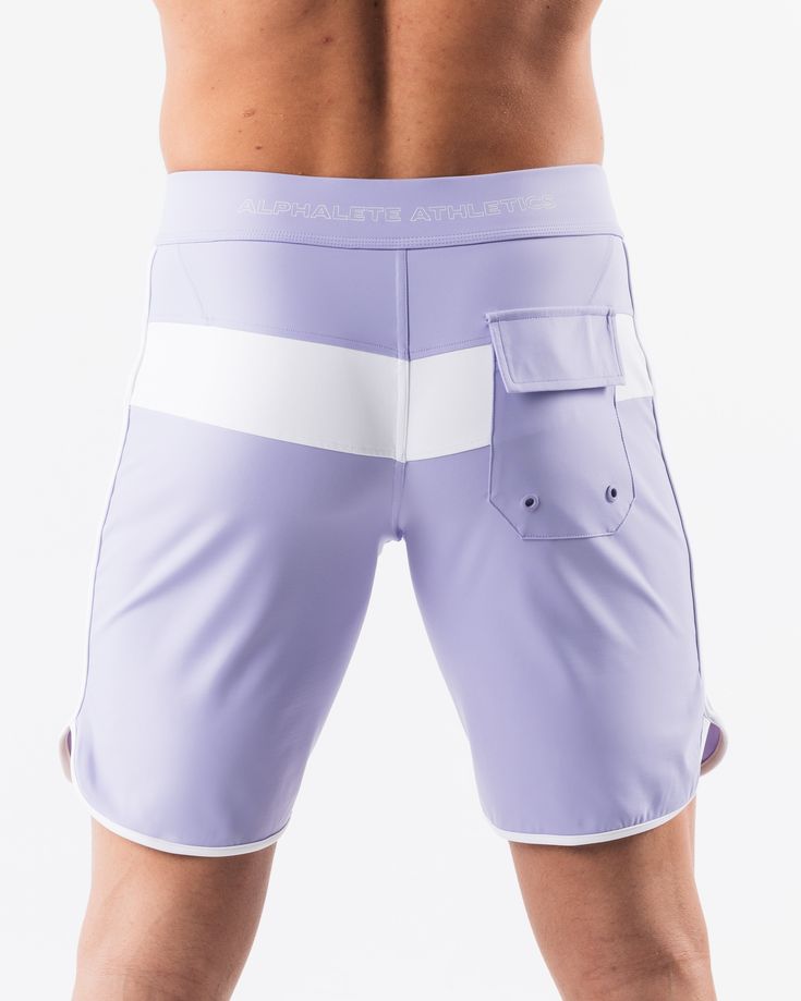 HIGHLIGHTS.. Unlined boardshort. 9” inseam Reflective branding at leg opening and back waistband Elastic waistband with adjustable self-tie drawcords Color-blocking panelling Water resistant fabric FIT SUGGESTION. This item runs true to Alphalete’s standard sizing.. Fit is based off of waist size in inches.. If you are between sizes, we recommend sizing up for a relaxed fit.. Eric is 6’2”/188cm, wearing a size 32. MATERIALS AND WASHING DIRECTIONS. 67% Nylon, 23% spandex. Due to the high saturati White Surfing Swim Trunks, Fitted White Swim Trunks For Surfing, White Fitted Swim Trunks For Surfing, White Training Bottoms With Elastic Side Panels, Sporty Fitted Surfing Bottoms, Summer Training Bottoms With Pockets, Sporty White Shorts For Water Sports, White Summer Bottoms With Elastic Side Panels, White Sporty Bottoms For Water Sports