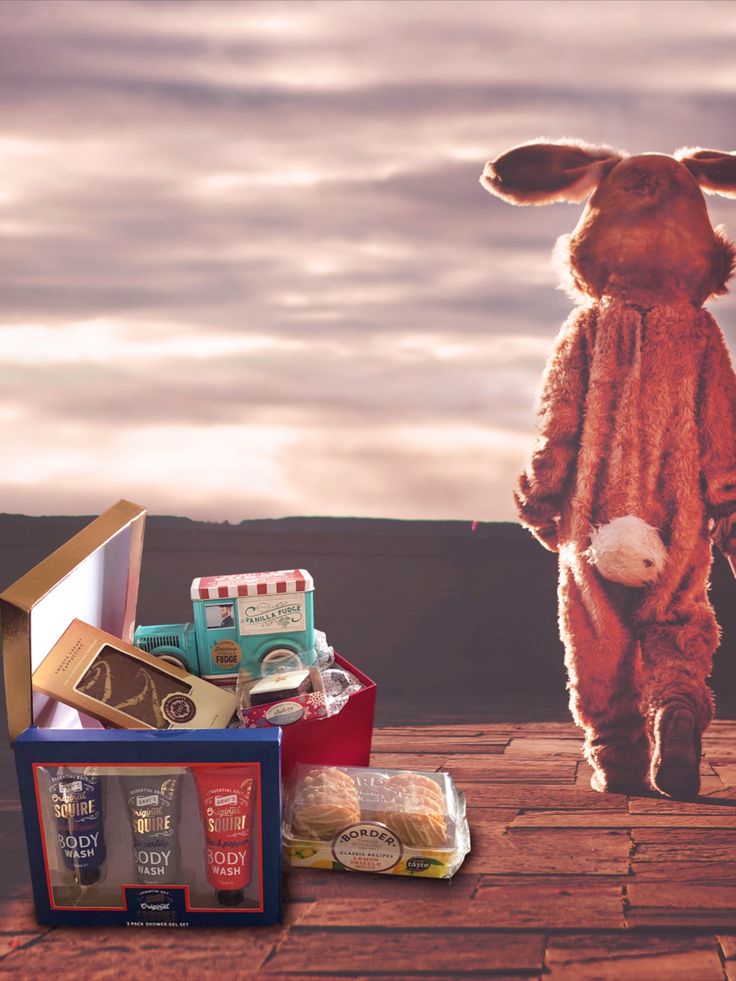 a stuffed animal is standing next to some food and other items on a wooden table