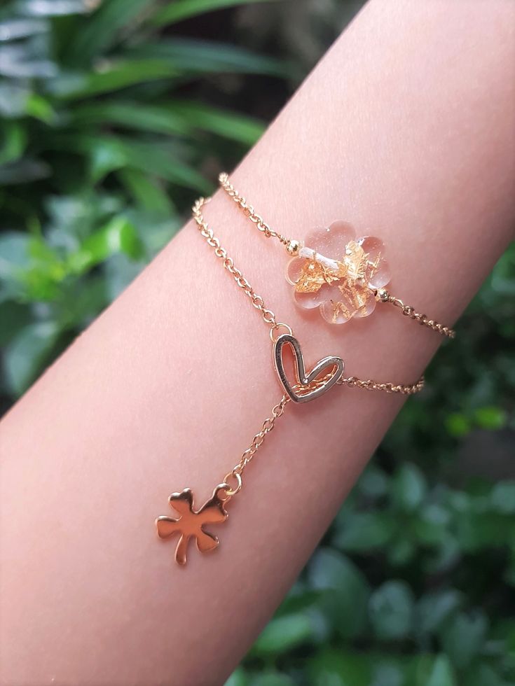 a woman's arm with two bracelets on it and one has an orange flower