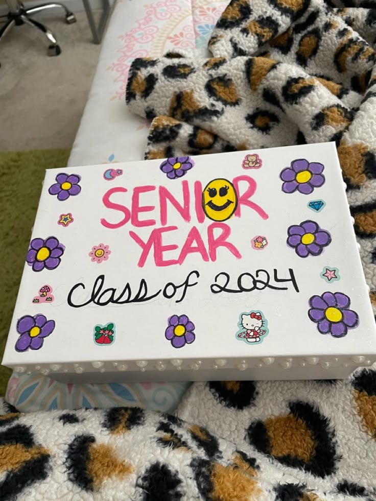 a sign that says senior year class of 2014 on the back of a bed covered in blankets