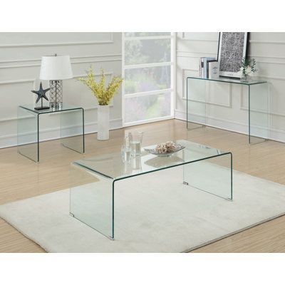 three glass tables sitting on top of a white rug