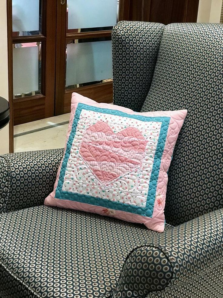 a blue chair with a pink heart pillow on it