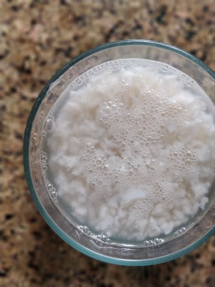 a glass filled with white liquid sitting on top of a counter