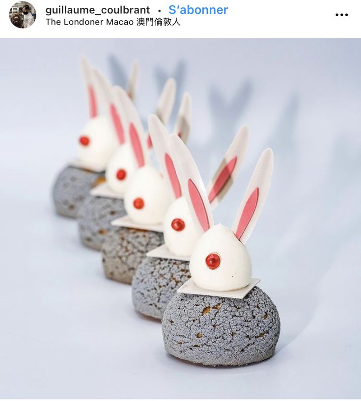 some rocks with bunny ears on them and red eyes are lined up in the shape of bunnies