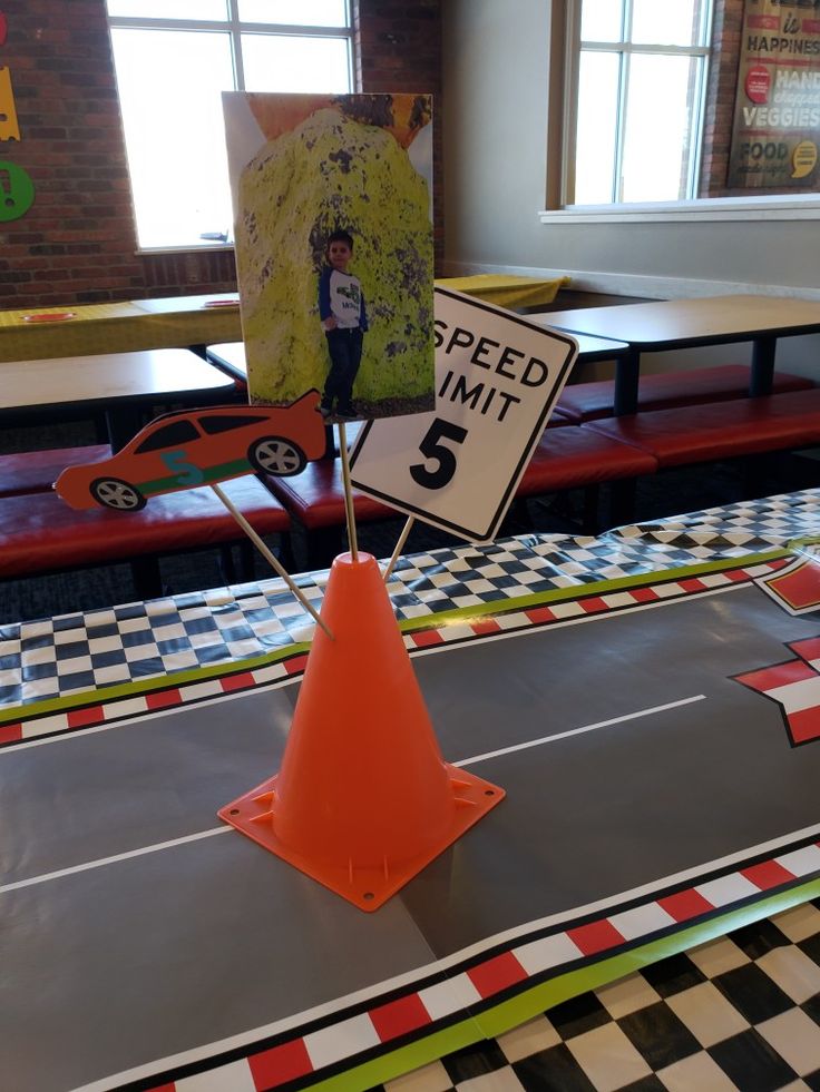 a speed limit sign sitting on top of a table next to an orange traffic cone