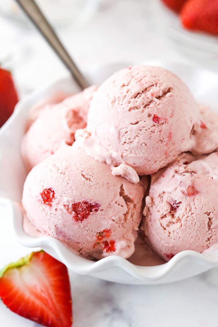 three scoops of strawberry ice cream in a white bowl