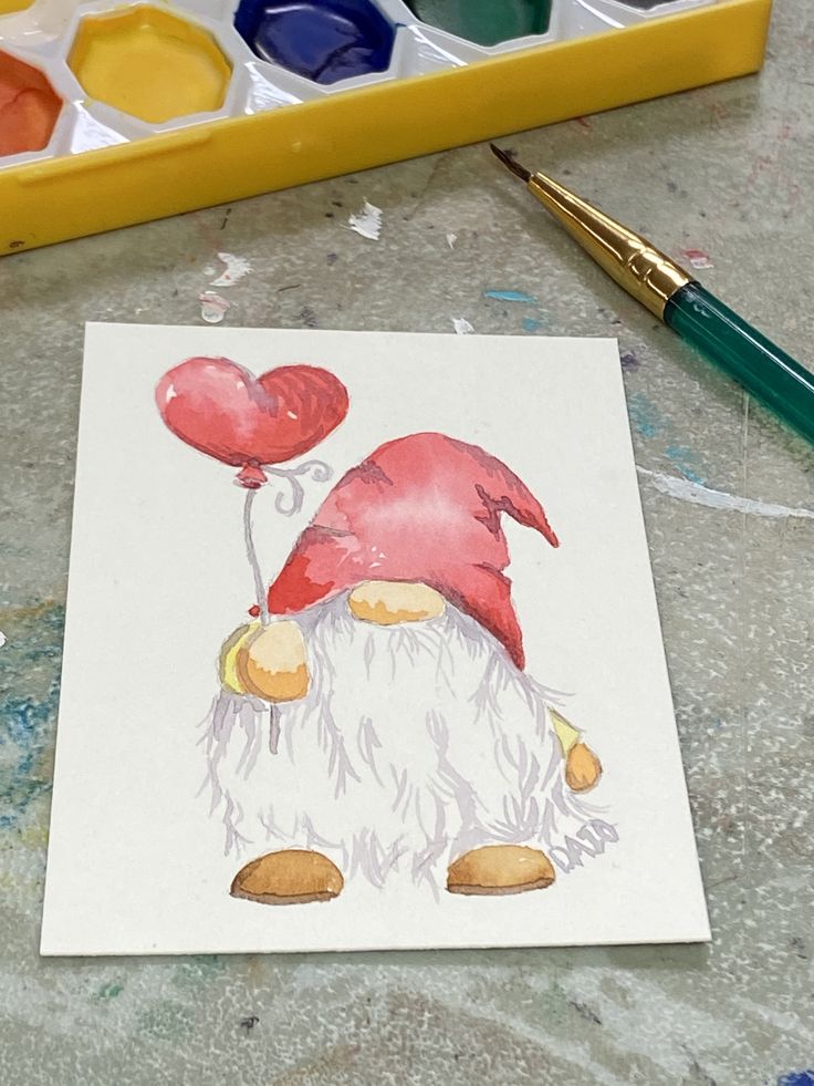 a drawing of a gnome with heart shaped balloons on it's head, next to paintbrushes and watercolors