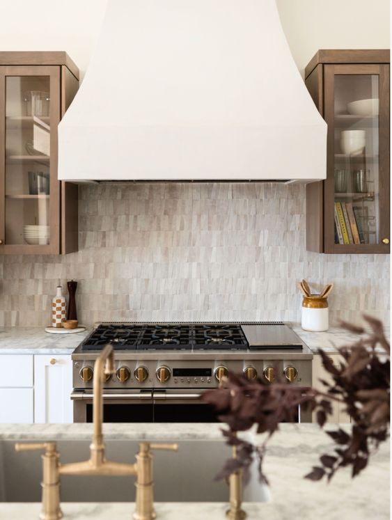 a stove top oven sitting inside of a kitchen next to wooden cabinets and counter tops