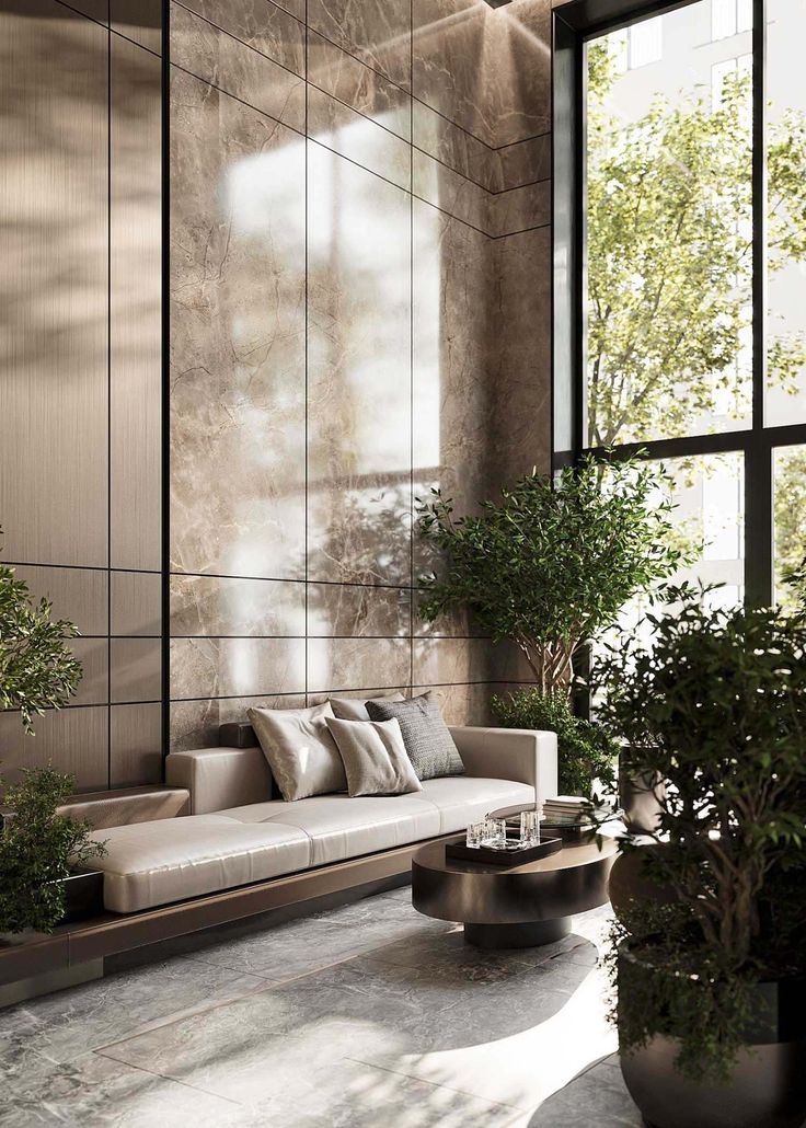 a living room filled with lots of furniture next to tall windows and potted plants