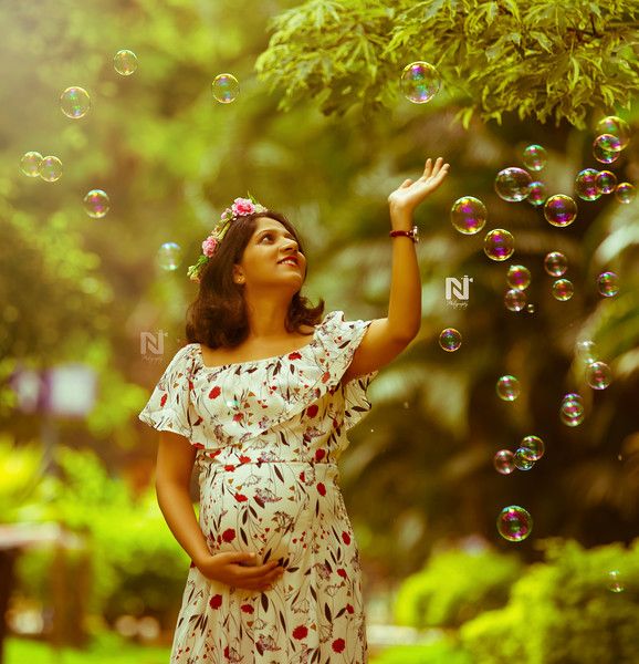 a pregnant woman is blowing bubbles in the air