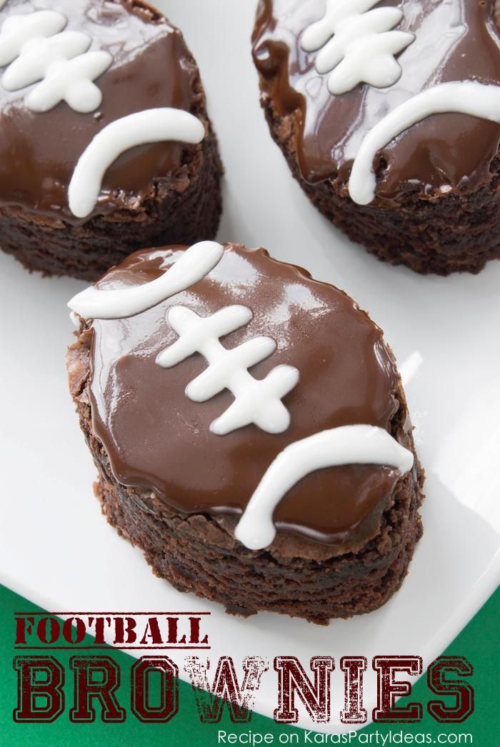 four brownie desserts with chocolate frosting and football decorations