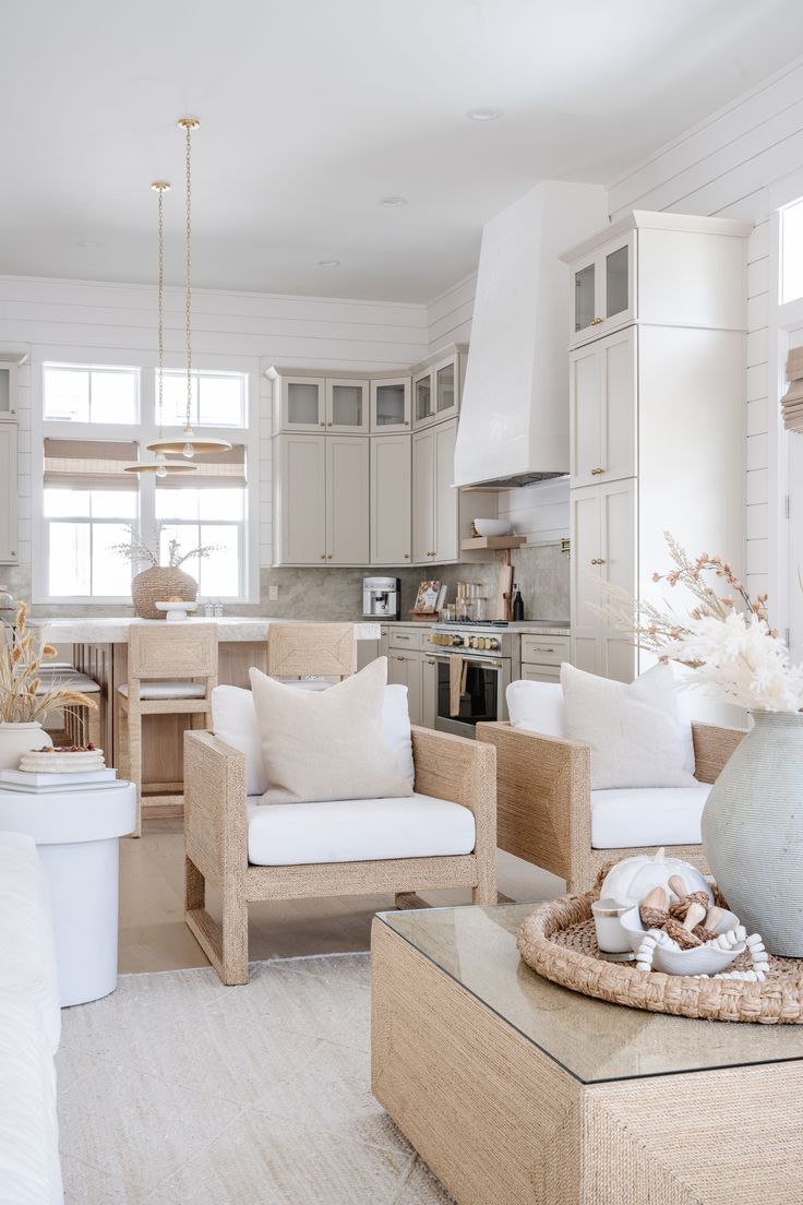 a living room filled with furniture and a kitchen in the backgroung area