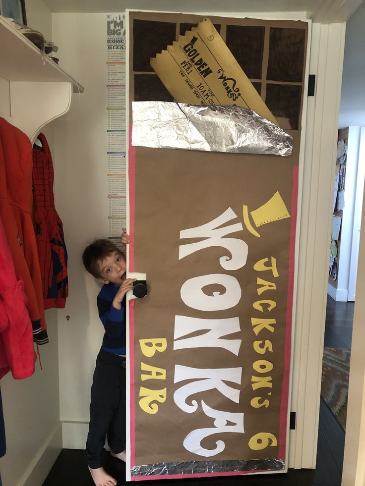 a young boy standing in front of a sign that says monkey bar on the door