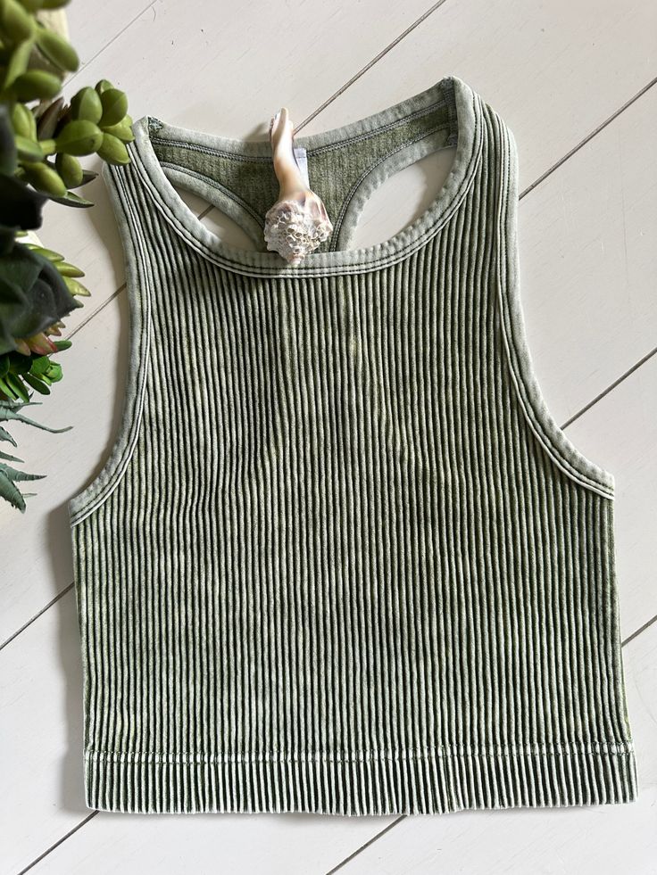 Rib Knit Cropped Cami in Olive. This cami is perfect for layering under your favorite tanks or styling with a kimono! It features: - vintage washed coloring - ribbed knit detailing - a tight fit- size up one for a more relaxed fit. Spring Ribbed Stretch Tops, Spring Cropped Acid Wash Top, Acid Wash Cropped Top For Spring, Acid Wash Fitted Tank Top For Spring, Ribbed Tops For Spring Layering, Spring Ribbed Tops For Layering, Spring Acid Wash Fitted Tank Top, Soft-washed Stretch Tops For Spring, Green Ribbed Tank Crop Top