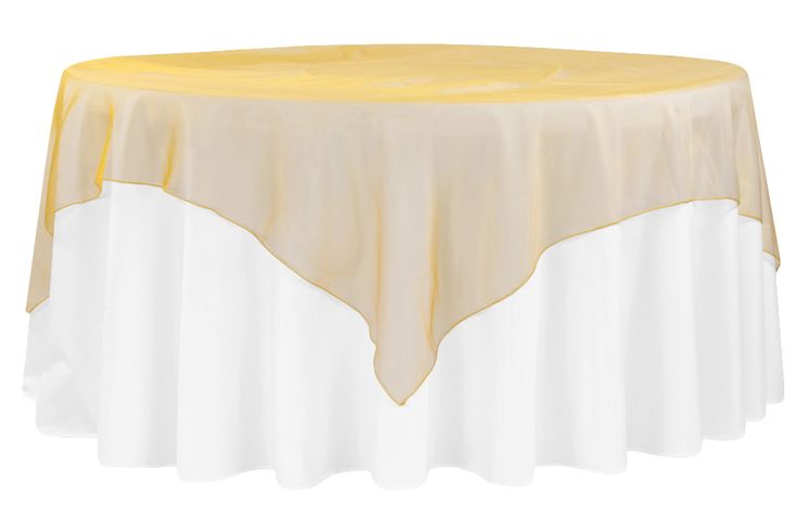 a yellow and white table cloth on top of a round table with a gold border