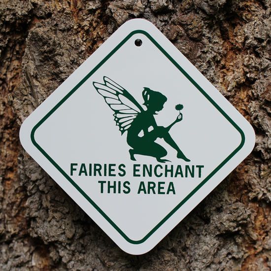 a sign that says fairies enchant this area on a tree