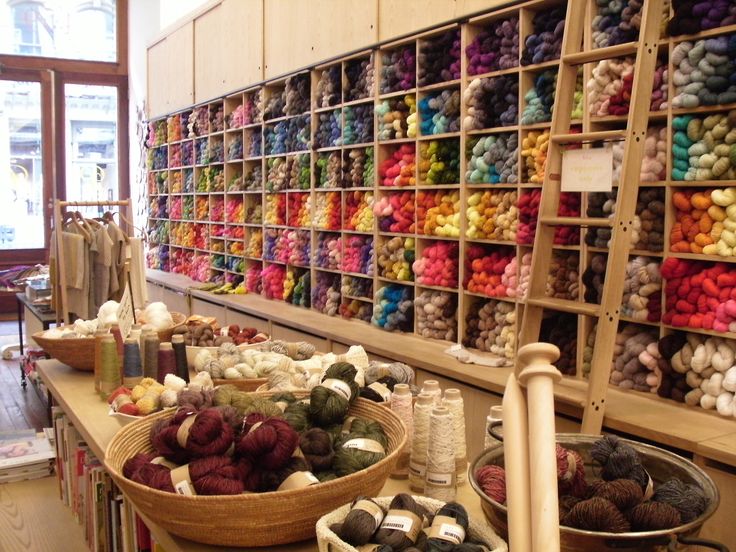 there are many balls of yarn on the shelves in this store, and two baskets full of them