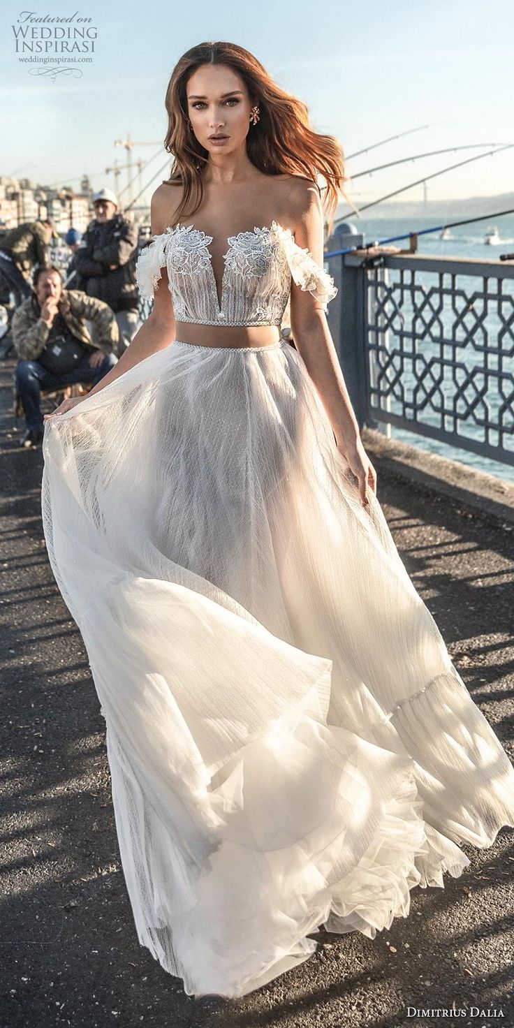 a woman in a white dress is walking down the street with other people behind her