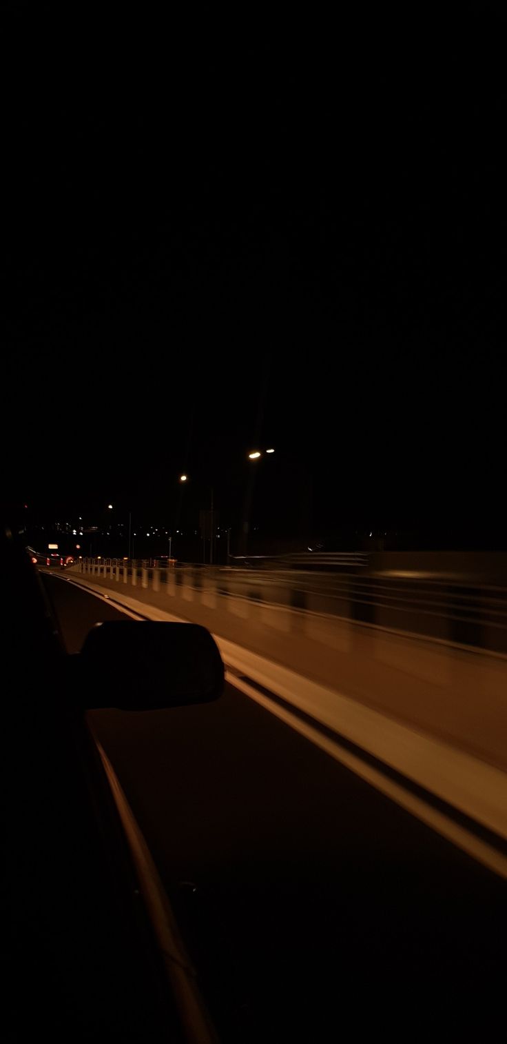 a car driving down the highway at night