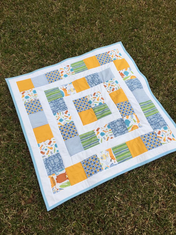 a patchwork quilt laying on the grass