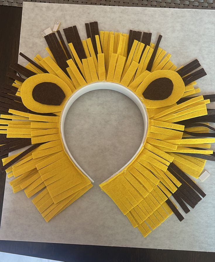 a yellow and brown paper craft with scissors in the shape of a lion's head