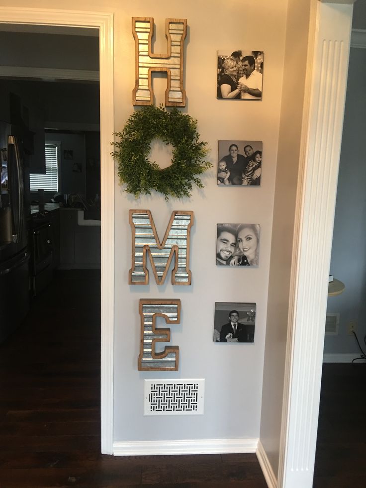 the wall is decorated with family photos and metal letters that spell out the word home